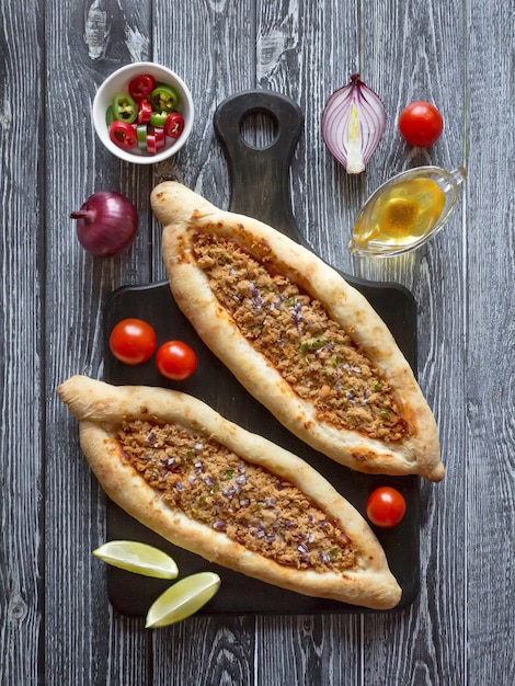 Pizza árabe lahmacun em uma mesa de madeira.