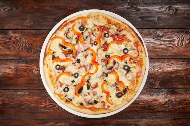 Pizza assada fresca na superfície de madeira