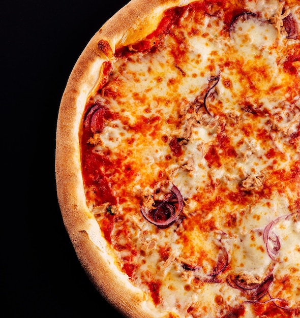 Pizza de atún al horno sobre fondo negro