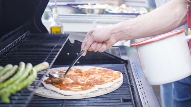 Pizza auf dem Gasgrill im Freien kochen.