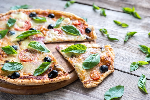 Pizza auf dem Holzbrett schneiden