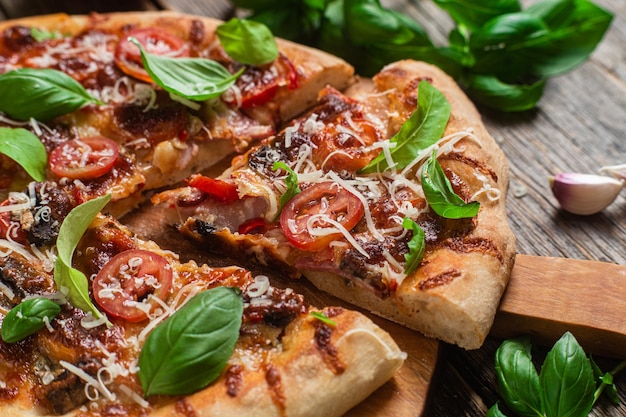 Pizza auf einem Holzbrett mit Basilikumblättern darauf