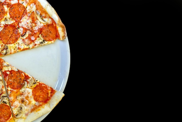 Pizza auf einem weißen Teller mit einem fehlenden Stück auf dunklem Hintergrund