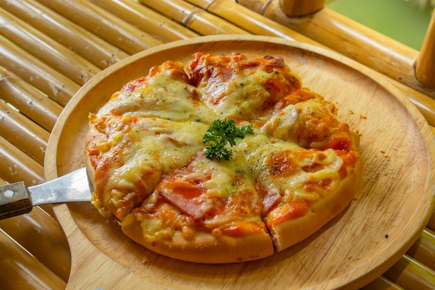 Pizza en una bandeja de madera.