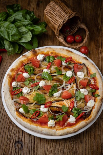 pizza con berenjena, queso, tomates y chiles en un restaurante