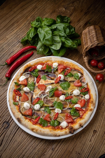 pizza con berenjena, queso, tomates y chiles en un restaurante