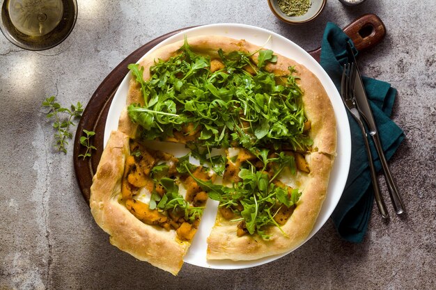 Pizza branca italiana tradicional com abóbora caramelizada de queijo taleggio e rúcula em cima da mesa