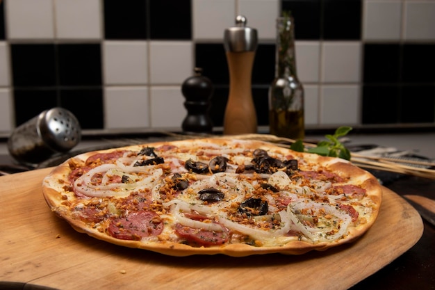 Foto pizza brasileira com queijo pepperoni cebola e azeitona preta