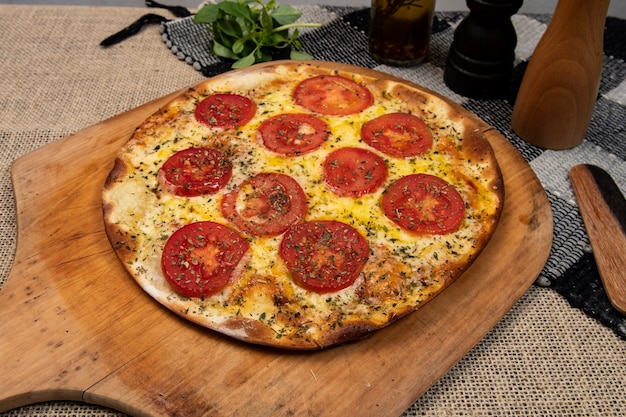 Pizza brasileña napolitana con queso mozzarella y rodajas de tomate con orégano, vista superior