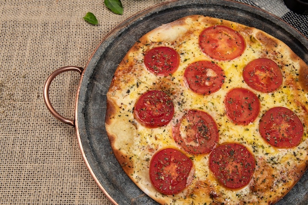 Pizza brasileña napolitana con queso mozzarella y rodajas de tomate con orégano, vista superior