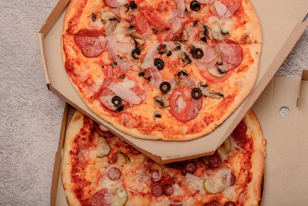 Pizza en caja de cartón corrugado marrón para llevar en mesa gris. redondo, pizza