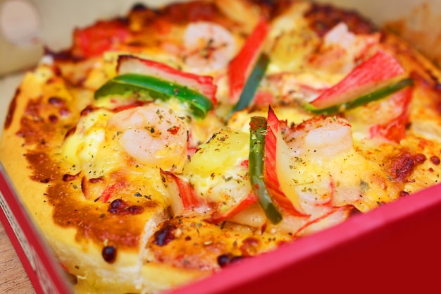 Pizza en caja en la mesa de madera