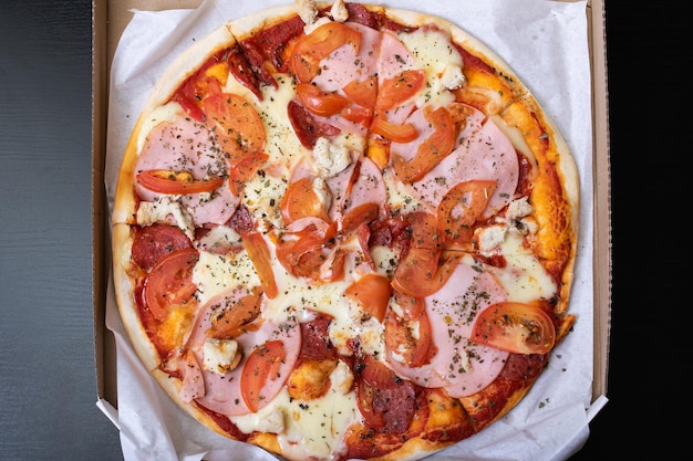 Pizza en una caja sobre una mesa de madera