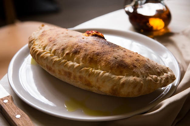 Pizza Calzone. Pizza napolitana rellena de queso, tomate y otros ingredientes como carne.