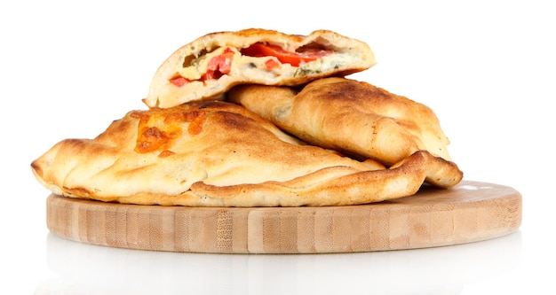 Foto pizza-calzones auf holzbrett, isoliert auf weiß