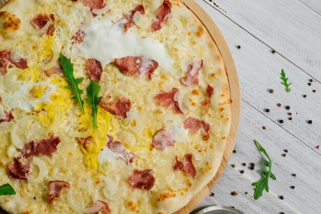 Foto pizza carbonare com mussarela, becon, ovo e cebola no fundo branco