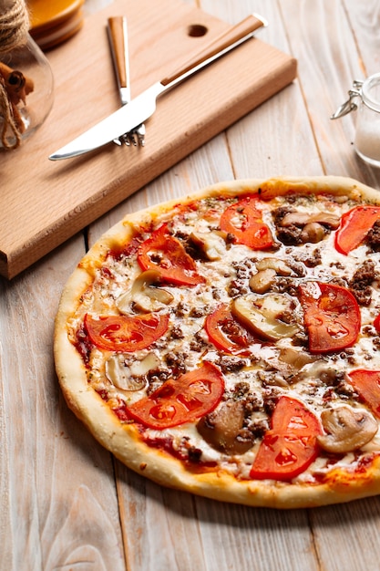 Pizza de carne picada con champiñones y tomates