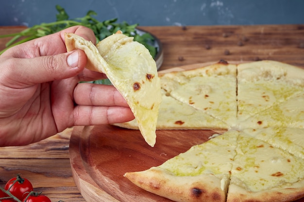 Pizza con carne, verduras y setas, fondo de madera