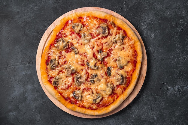 Pizza caseira com queijo tomate e cogumelos em um fundo escuro Vista superior fechada