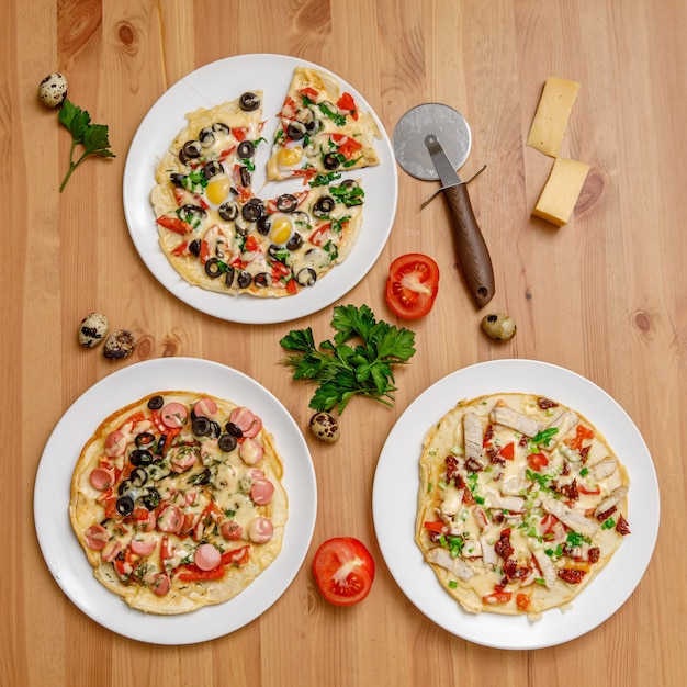 Pizza caseira com tomate e queijo na mesa de madeira