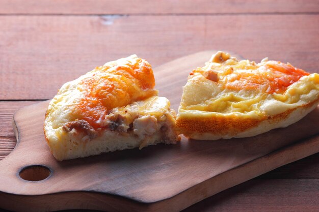 Pizza caseira em tábua de corte Pizza em fatias em fundo de madeira em estilo rústico cozinha italiana