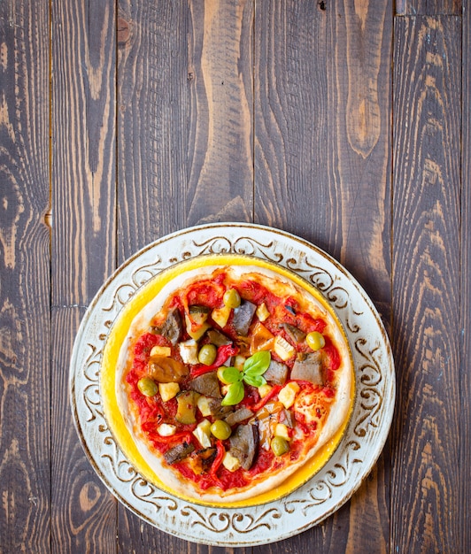 Pizza caseira fresca com vegetais diferentes em um fundo de madeira