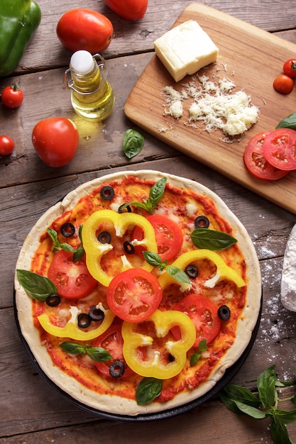 Pizza caseira italiana em fatias de páprica com ingredientes na mesa de madeira.