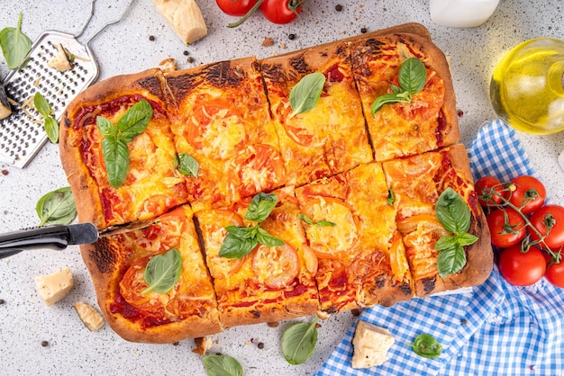 Pizza caseira retangular com tomates e manjericão
