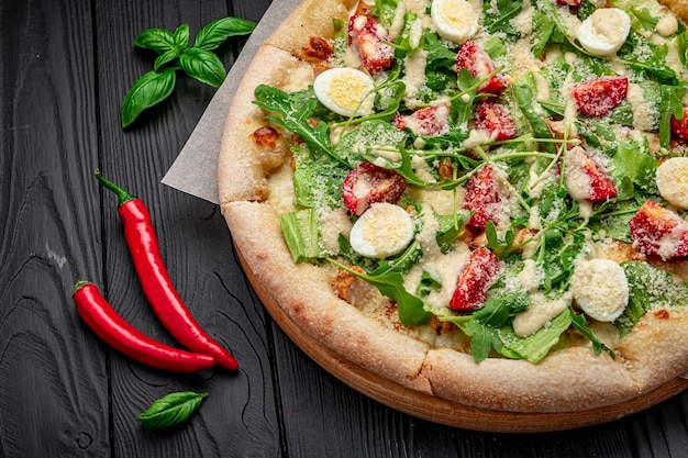 Pizza casera con ensalada César una interesante porción de ensalada con carne de pollo