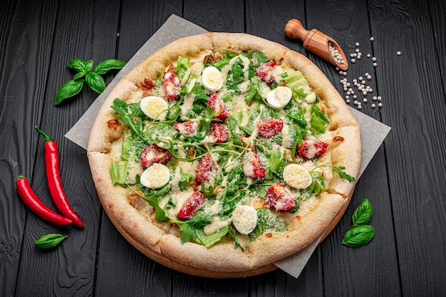 Pizza casera con ensalada César una interesante porción de ensalada con carne de pollo