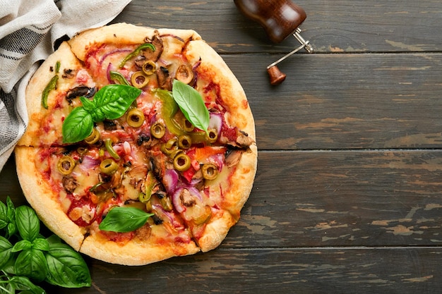 Pizza casera Pizza tradicional napolitana con aceitunas pimientos cebollas y hongos en fondos de mesa de madera comida tradicional italiana Vista superior Maqueta