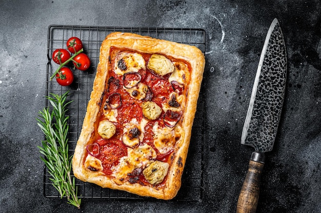 Pizza casera con salami, mozzarella, tomates y queso Con fondo negro Vista superior