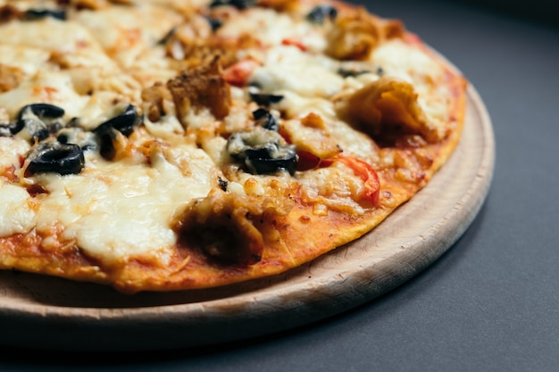 Pizza casera con tomate, mozzarella y albahaca. Vista superior con espacio de copia en la mesa de piedra oscura