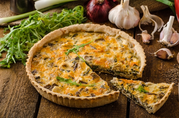 Foto pizza con champiñones y verduras en la mesa de madera