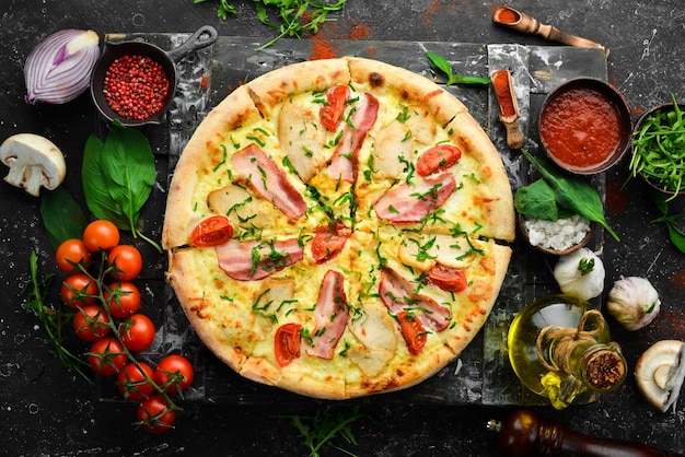 Pizza com bacon de frango e tomate cereja cozinha italiana em um fundo preto