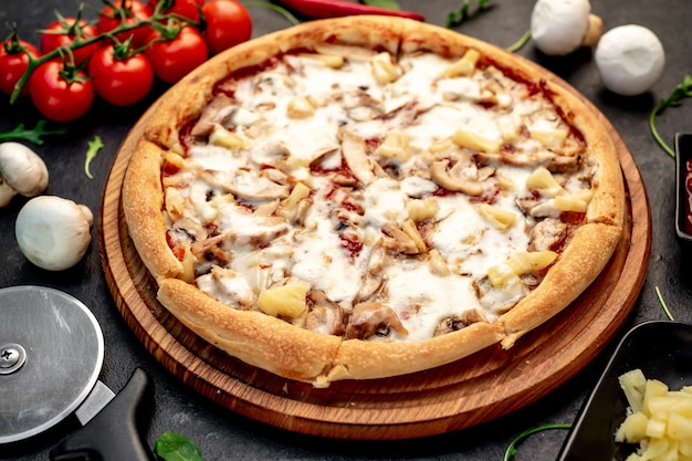 pizza com cogumelos de frango e abacaxi em um fundo de pedra