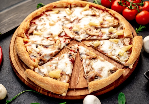 pizza com cogumelos de frango e abacaxi em um fundo de pedra