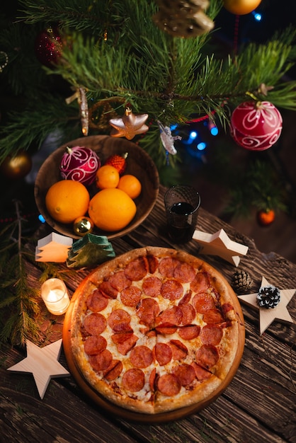 Pizza com enfeites de natal na mesa de madeira