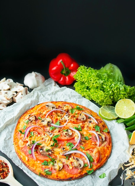 Pizza com frango, queijo e cogumelos em um fundo escuro. Vista de cima. Copie o espaço.