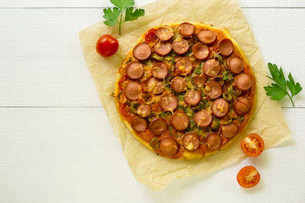 Pizza com linguiça, azeitonas e queijo, sobre um fundo claro