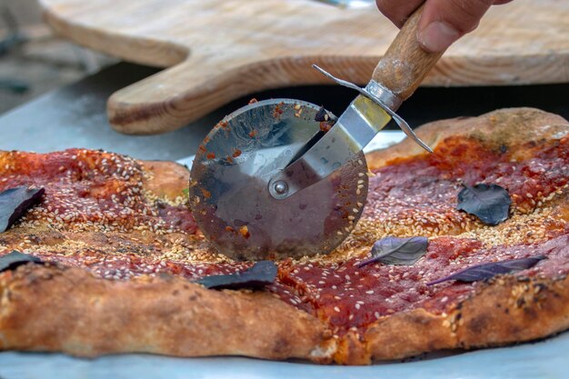 Pizza com molho de tomate, gergelim e manjericão.