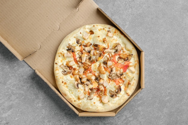 Pizza com peito de frango e cogumelos champignon em caixa de papelão