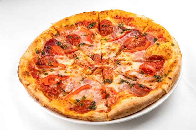 Pizza com presunto, salsicha e tomate em um prato branco