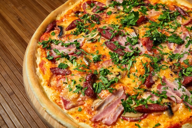 Pizza com queijo, bacon e ervas em um prato de madeira