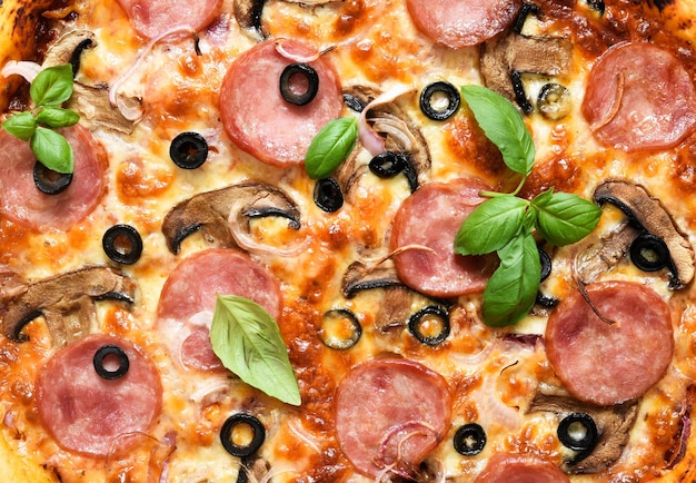 Pizza com salame, cogumelos e molho de tomate em um fundo preto. vista de cima.