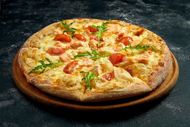 Pizza com salmão, tomate e rúcula em um fundo de pedra preta. vista de ângulo de 45 graus. Close-up, foco seletivo