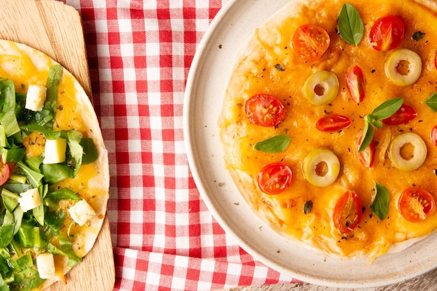 Pizza com tomate e queijo em um prato de cerâmica artesanal em vista superior