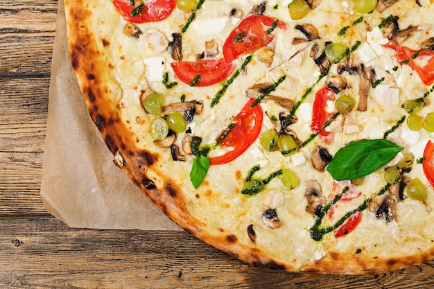 Pizza com tomate, mussarela, cogumelos e pesto de manjericão. Pizza "Caprese". Comida italiana. Vista do topo