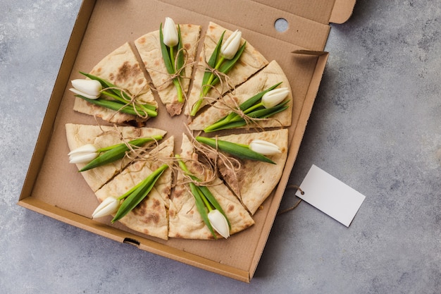 Pizza creativa con tulipanes flores en caja de papel