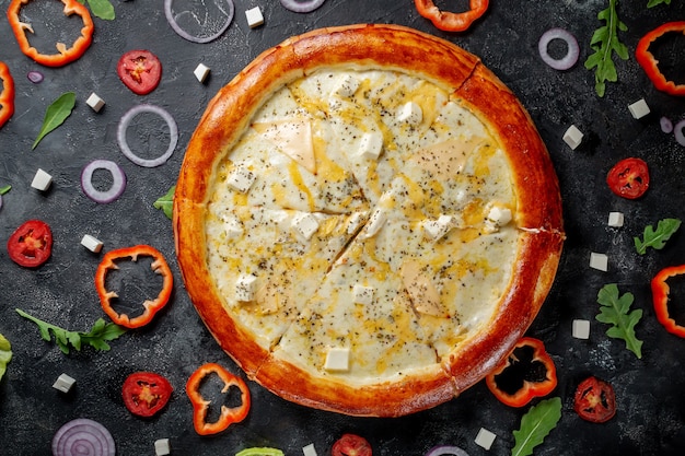 Pizza cremosa com queijo. Pizza italiana caseira fresca de Margherita com azeitonas e pimentão vermelho em um fundo escuro